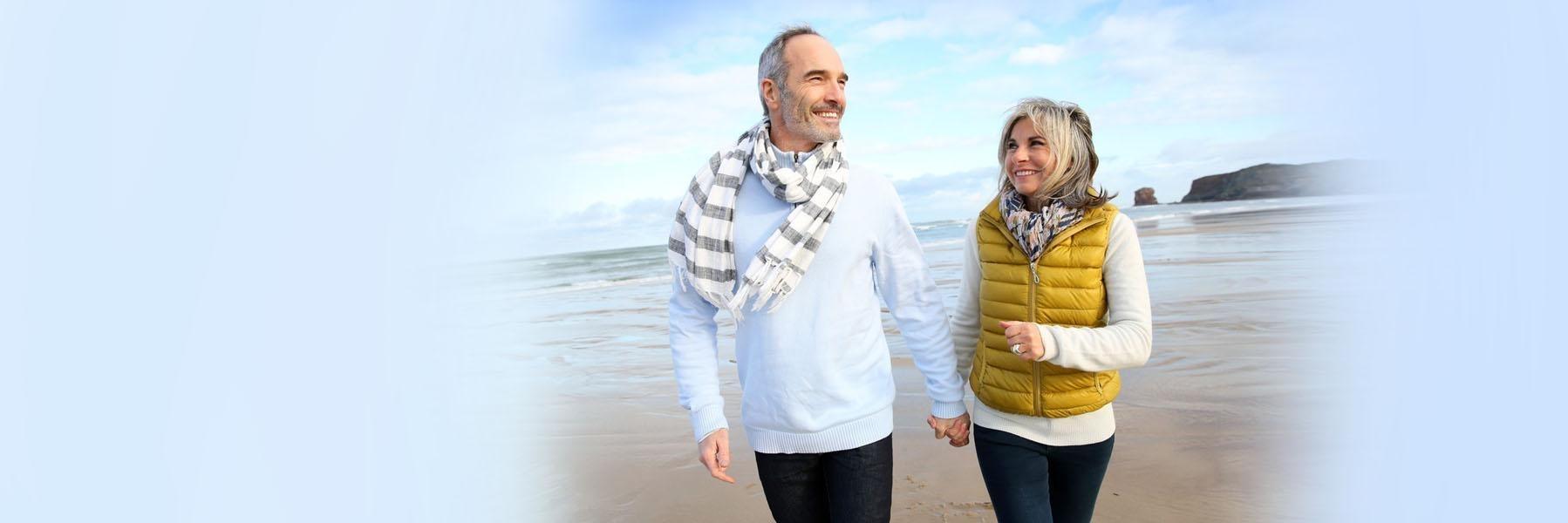 Older couple walking on beach | Periodontal Disease Jonesboro AR