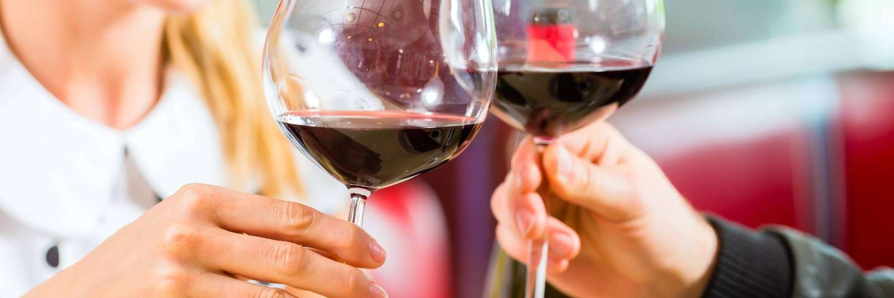 Two people clinking wine glasses | holiday dental tips