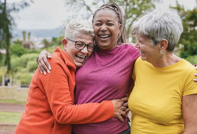A laughing group of older women in the park