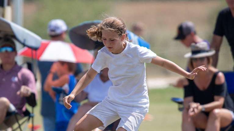 A child playing soccer in a field