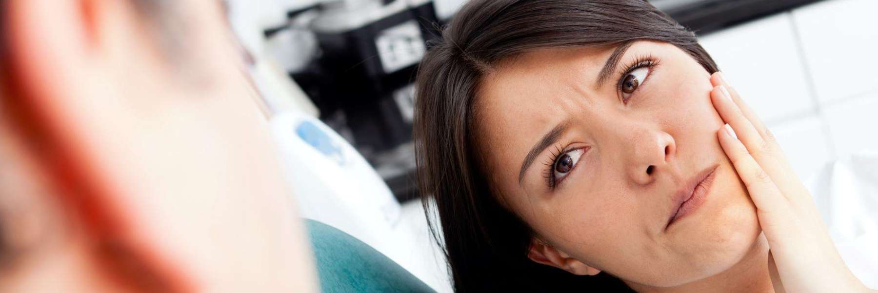 A woman with a toothache talking to her dentist